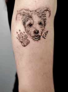 tattoo portrait of a dog with his paw and his name 'felix'